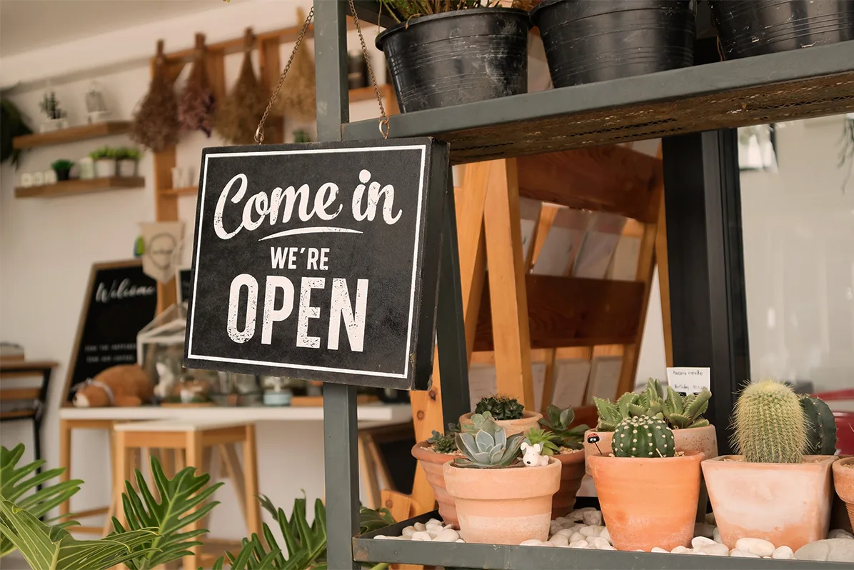 SURFHOUSE Asbury Park retail experience: "Come In; We're Open" sign among potted cacti