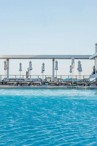 Rooftop pool in Asbury Park NJ with lounge chairs and umbrellas