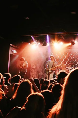 Things to do in Asbury Park NJ: Live Music band on stage under bright lights