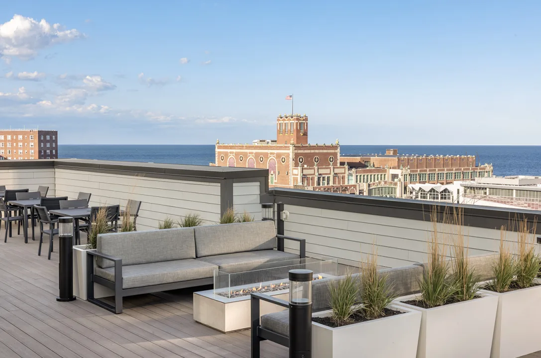 Luxury Amenities: Surfhouse rooftop lounge with fire pit overlooking the Asbury Park boardwalk.